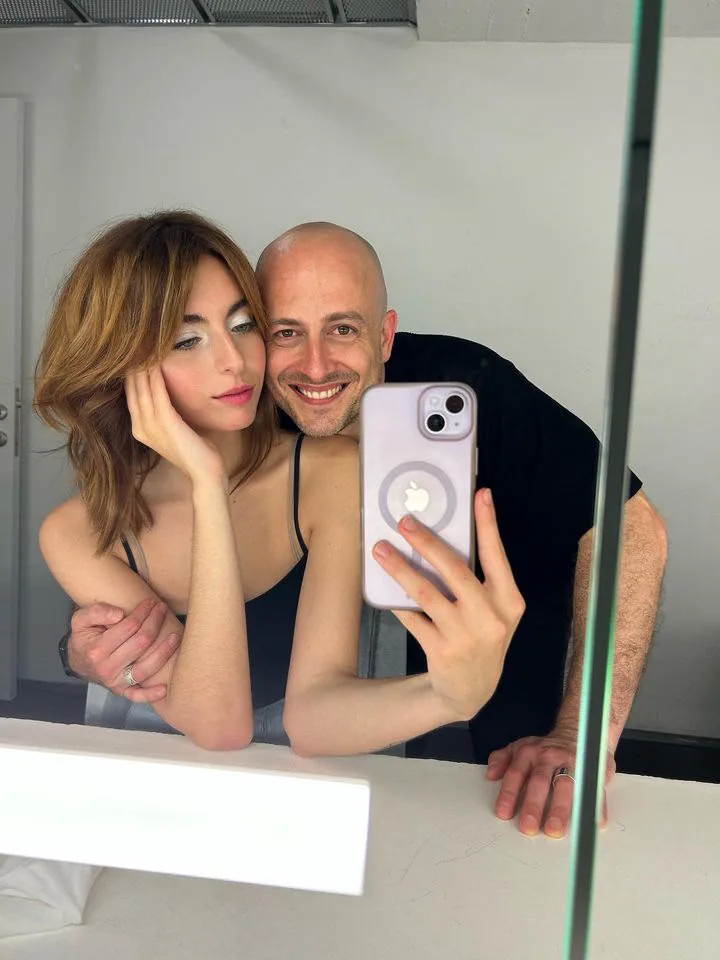 Diego Avellini insieme a una modella davanti allo specchio