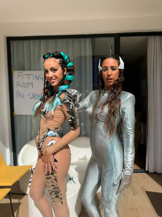 Due modelle con look scenici nel backstage di un evento hair