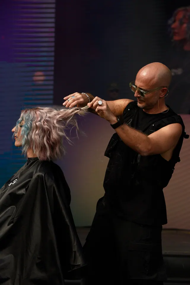 Diego Avellini costruisce un look davanti al pubblico durante una performance hair