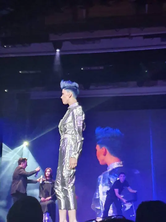 Modella sul palco con un look hair e moda completo