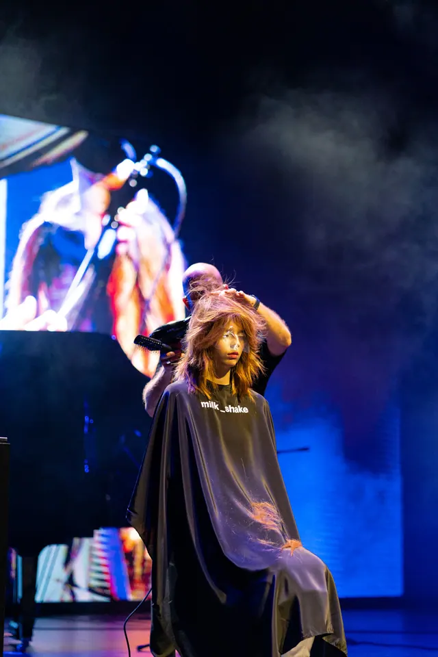 Diego Avellini rifinisce il movimento dei capelli su un palco illuminato