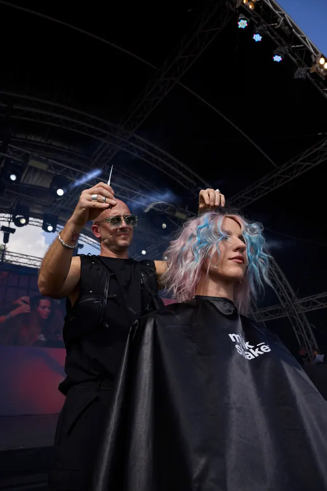 Diego Avellini lavora sui capelli di una modella durante uno show dal vivo