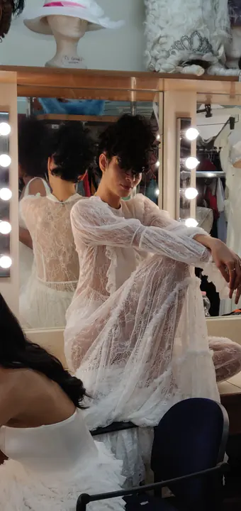Modella in abito bianco durante la preparazione nel backstage