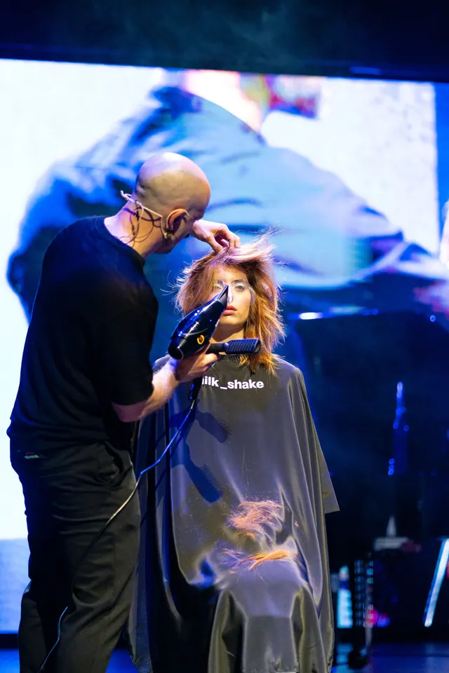 Taglio dal vivo sotto le luci blu di uno show hair