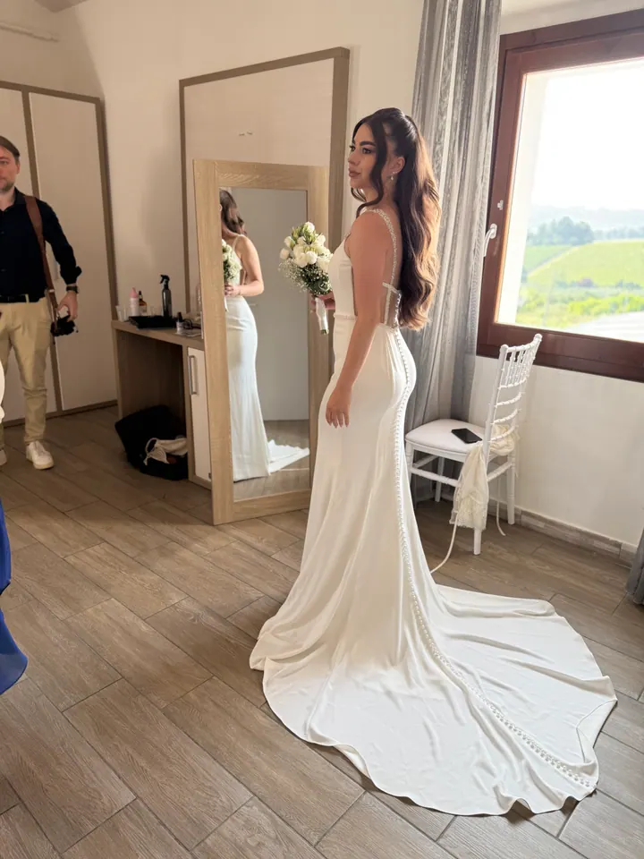 Sposa in abito bianco durante la preparazione del look