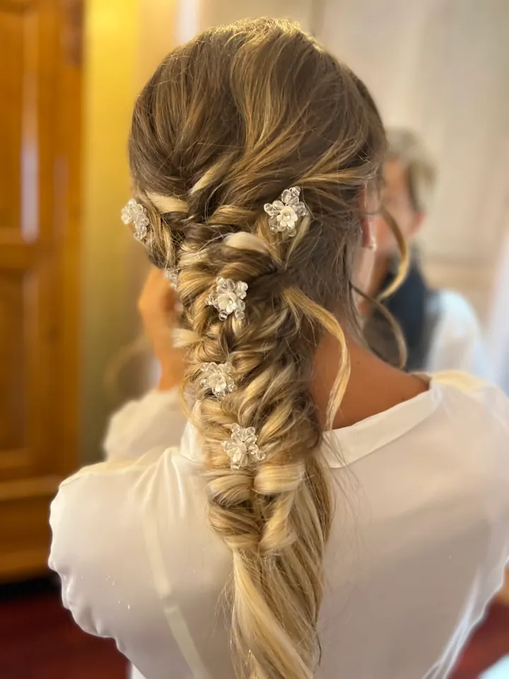 Acconciatura sposa intrecciata con piccoli accessori luminosi
